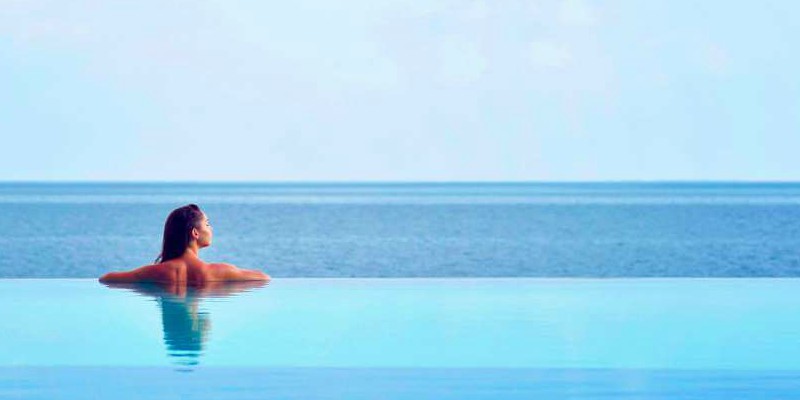 Woman relaxing in an infinity pool