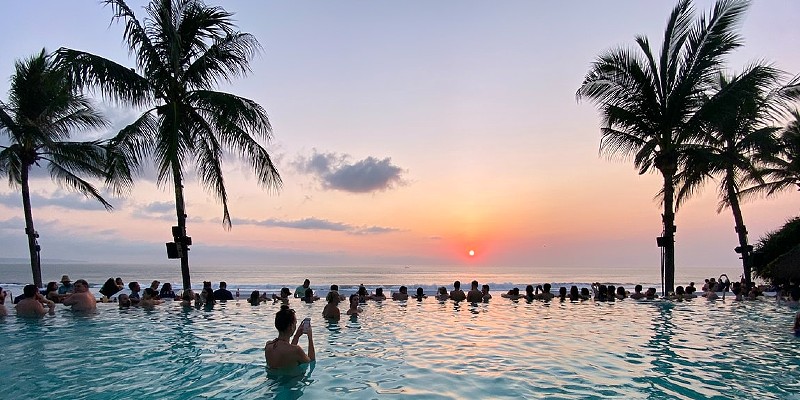 People watching the sunset in Bali from an infinity pool 