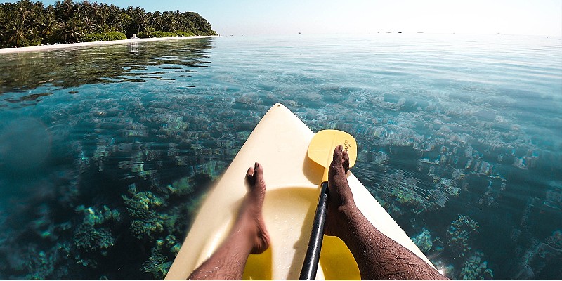 man kayaking over crystal clear waters