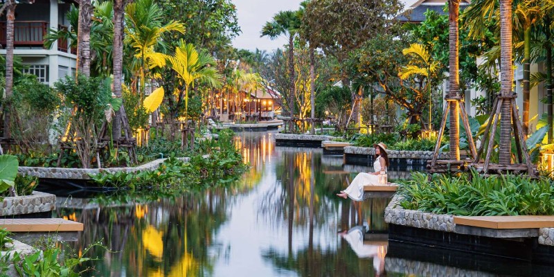 Woman sits admiring the canal at Grand Mercure Khao Lak Bangsak, Thailand