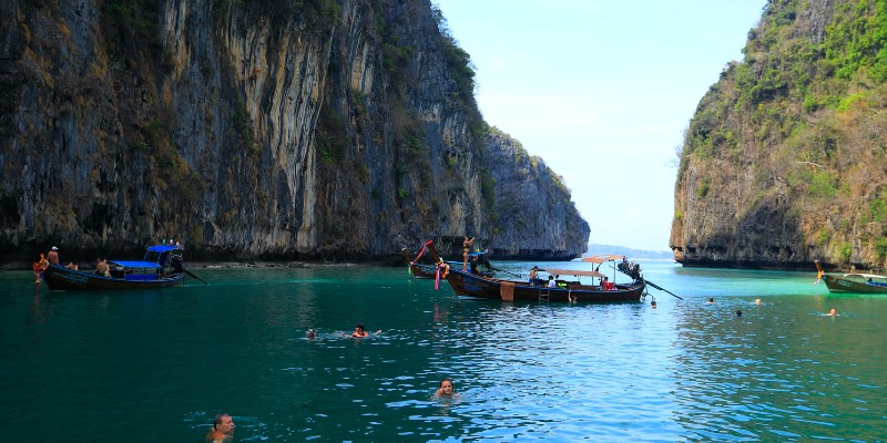 People and boats in the water at the Phi Phi Islands in Thailand