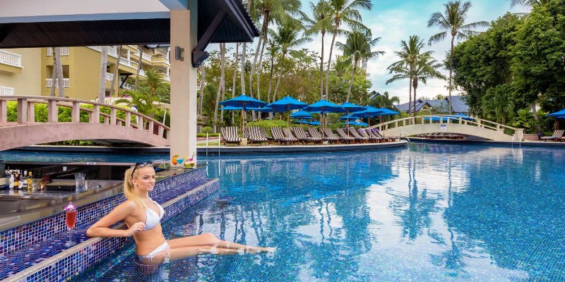 Woman relaxing at the swim-up bar at Angsana Thailand resort