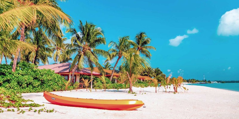 A canoe lying on the sand of a beach in the Maldives