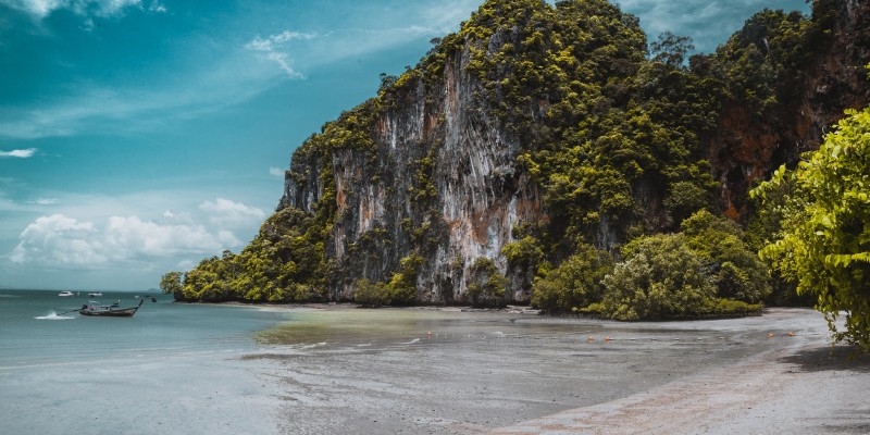 A beach in Thailand surrounded by limestone cliffs