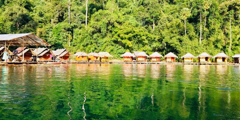 A still river and water huts in Thailand