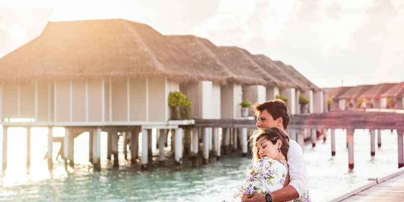 A couple by water villas in the Maldives