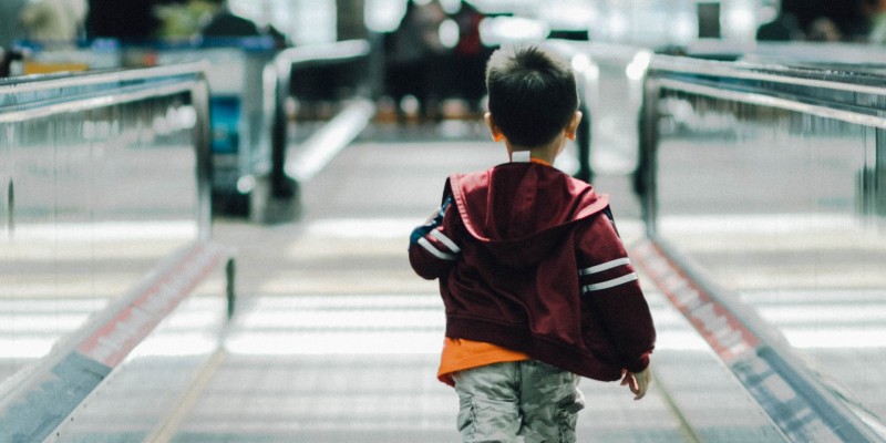 Child running on a walking belt in the airport