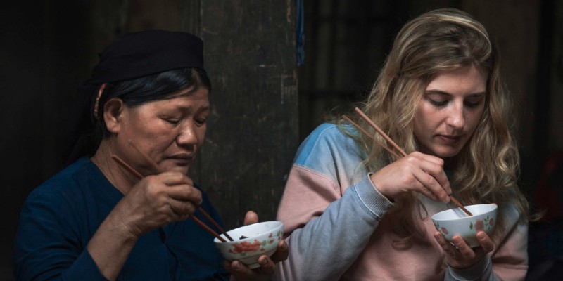 Old Thai lady eats with a young western girl