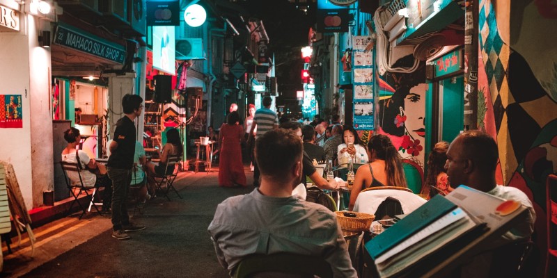 People drinking in a street outside a restaurant in Asia
