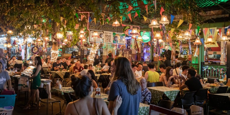 People exploring a night market food court in Thailand