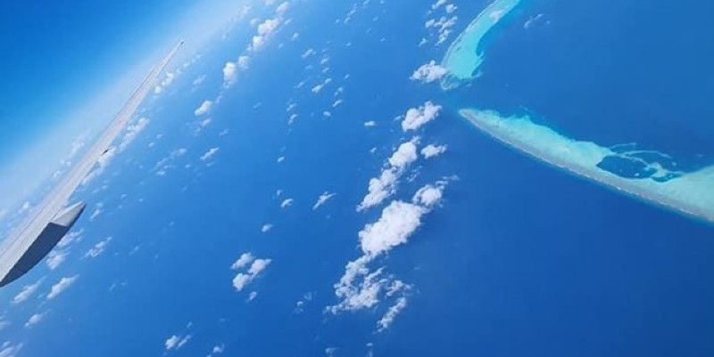 View from the window at a seaplane flying over the Maldives