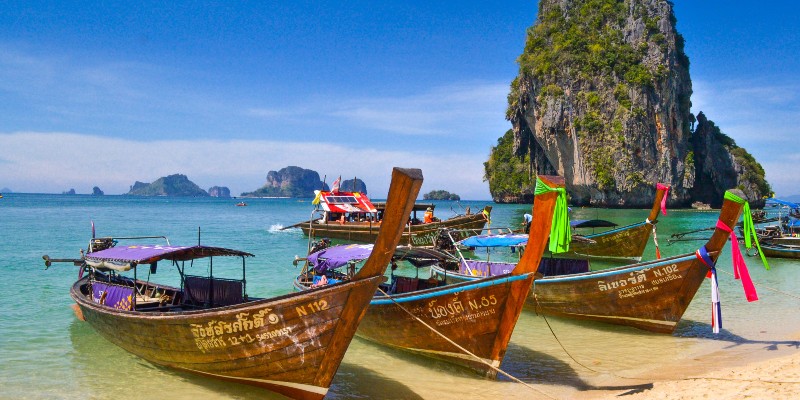 Traditional Thai fishing boats lined up on the beach at Phang Nga Bay