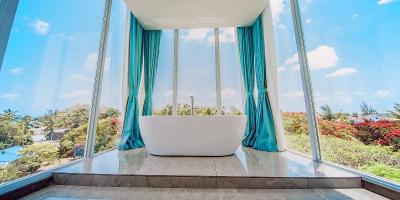 Standalone bath circled by floor-to-ceiling windows