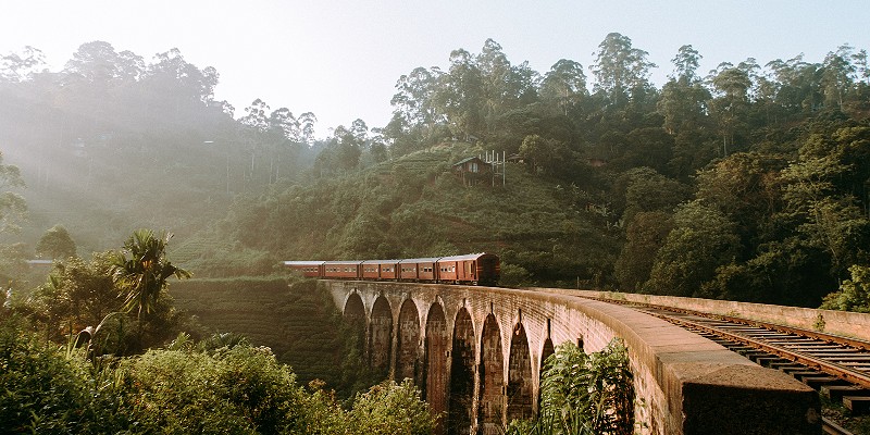 Train rolling over the tracks of nine arch bridge in Sri Lanka