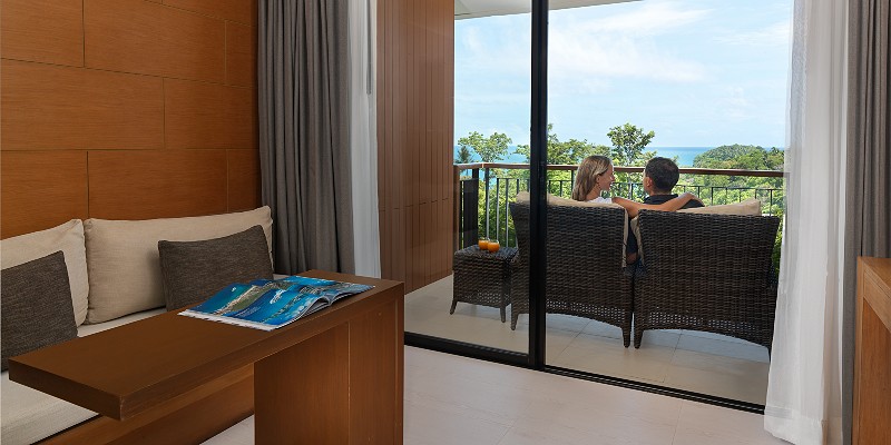 Two people sitting on the balcony of a sea view room