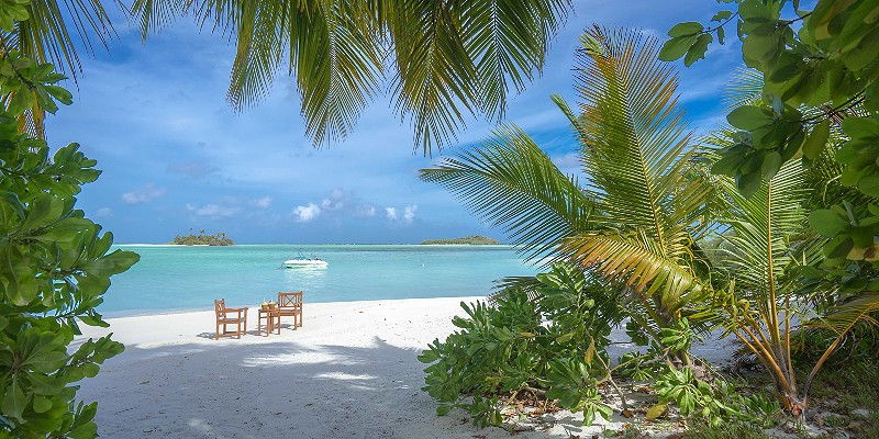 Two wooden chairs on the beach at Rihiveli Maldives 